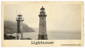 A tall lighthouse with a black and white striped pattern standing on a rocky shore.