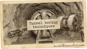A tunnel boring machine cutting through rock inside a tunnel showing the tunneling process.