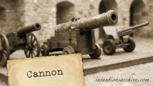 A vintage cannon with a weathered barrel and a wooden wheel, displayed as an invention.