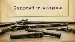 A collection of old gunpowder weapons, including pistols and rifles, on a display table.