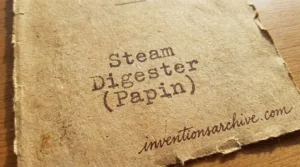 A steam digester (Papin) with a metal chamber and pressure gauge used for cooking under high pressur…